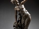 une image d'une statue en bronze représentant une femme tenant un oiseau