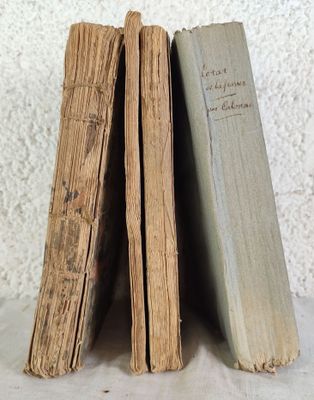 trois vieux livres sont empilés sur une table