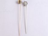 pair of silver and gold earrings with a diamond on them