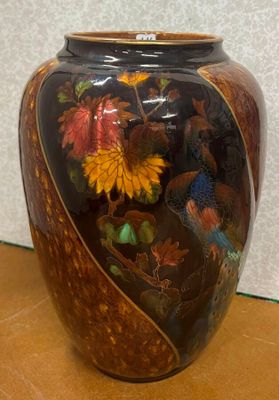 un vase sur lequel sont peints un oiseau et des fleurs