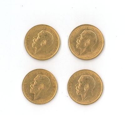 quatre types différents de pièces d'or sur une surface blanche
