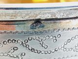 a close up of a silver bowl with a design on it
