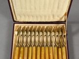 eight forks in a box with a spoon inside of it