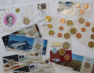 a lot of different coins and postcards on a table