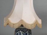 a blue and white lamp with a white shade on it