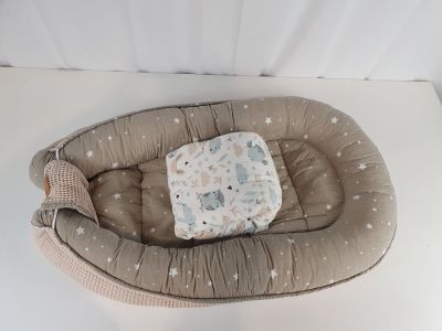 un lit de bébé sur lequel est posé un oreiller