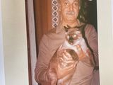 a picture of a man holding a cat in his arms