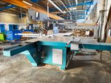 a machine that is cutting a piece of wood in a factory