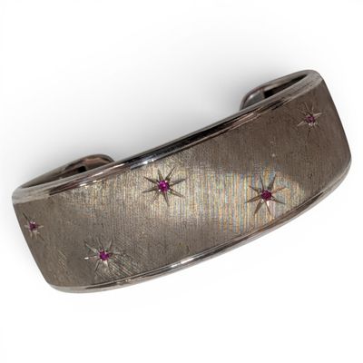 an image of a silver bracelet with pink stones on a white background