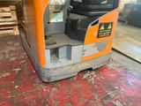an orange and black forklift truck in a warehouse