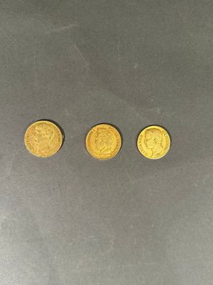 trois pièces d'or posées les unes à côté des autres sur une table