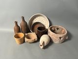 Plusieurs types de poteries sont exposés sur une surface grise