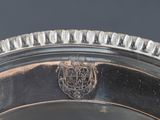 an image of a silver plate with a crest on it