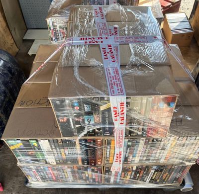 a large stack of books wrapped in plastic on top of a carton