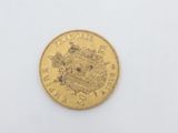 a close up of a gold coin on a white surface