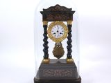 a small clock under a glass dome on a table