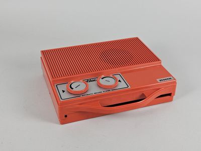 un appareil électronique orange posé sur une surface blanche