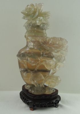 un vase contenant des fleurs, posé sur un socle