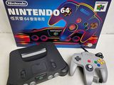 a nintendo 64 game console with a controller in front of it