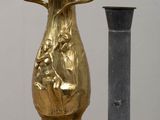 a gold vase sitting next to a black vase on a table