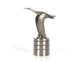 une statue en argent représentant un oiseau posé sur une pile de pièces d'argent