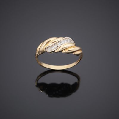 a yellow gold ring with diamonds on a black surface