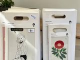 two boxes with drawings on them sitting on a table