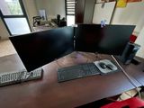 a desk with two computer monitors and a keyboard on it