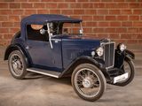 a vintage car parked in front of a brick wall