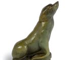 une image représentant une statue d'un chien assis sur un rocher