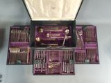 un coffret violet contenant des couverts, posé sur une table