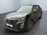 Le SUV noir est garé dans une grande pièce au sol noir.