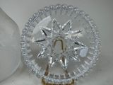 a glass plate with a star design on it next to a glass vase