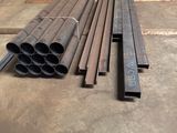 several steel pipes are stacked on the floor in a warehouse