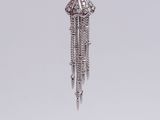 a close up of a silver necklace with a tassel hanging from it