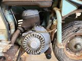 a close up of an old motorcycle with a rusty engine