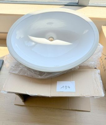 un bol blanc posé sur une boîte près d'une fenêtre