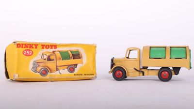 yellow toy truck next to a yellow box on a white surface