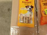 two packages of dog treats sitting on top of a cardboard box
