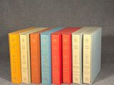 six books are lined up in a row on a gray surface