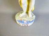 une figurine représentant un homme tenant une planche de surf