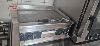 stainless steel counter top with oven and toaster on it in a commercial kitchen