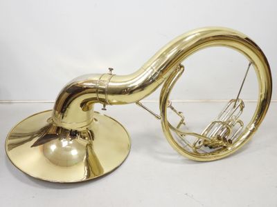 une image représentant un instrument de musique en laiton posé sur une surface blanche