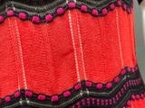 a close up of a woman ' s red dress with black and pink trim