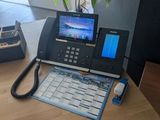 a desk with a phone and a laptop on it