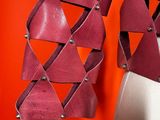 a close up of a pair of red leather earrings hanging from a hook