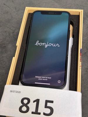 an iphone is sitting in a box with a pen on top of it