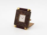 an image of a small square clock with roman numerals on the face