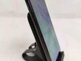a close up of a cell phone on a stand on a white surface
