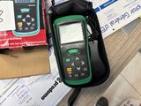 a green and black multimeter sitting on top of a table